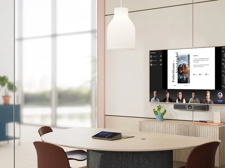 Small huddle room with a round table, touch controller and video display
