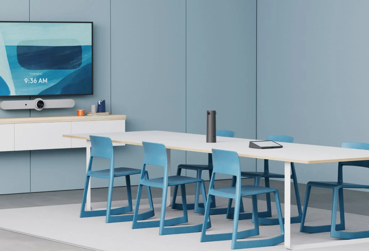 Meeting room with a wall-mounted display, video bar and table microphone
